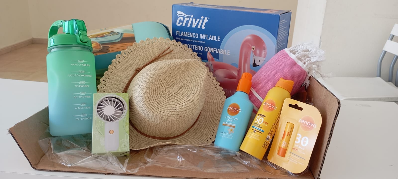 Cesta adulto: · Inflable flamenco gigante 2 m · Sombrero playero · Botella de agua · Toalla de playa · Nevera · Mini ventilador · Protector solar 50 After sun · Labial con protección solar 30